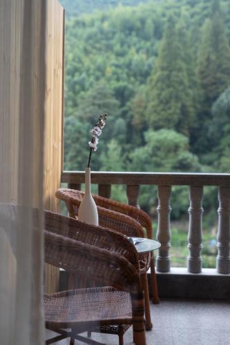 a vase sitting on a chair on a balcony at Moganshan Bamboo View Guesthouse in Deqing