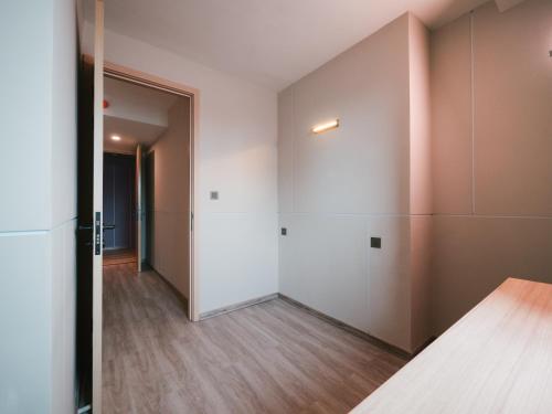 an empty room with white walls and wooden floors at 56 Hotel in Bangna