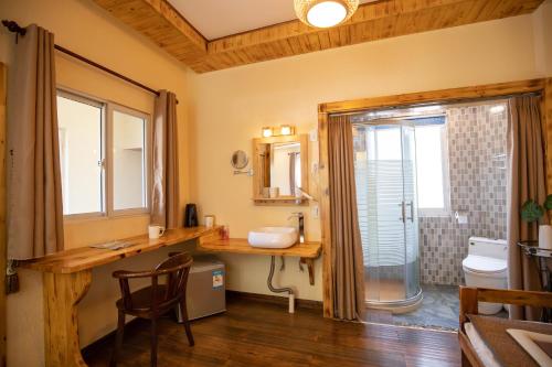 y baño con lavabo y ducha acristalada. en Moganshan Bamboo View Guesthouse, en Deqing