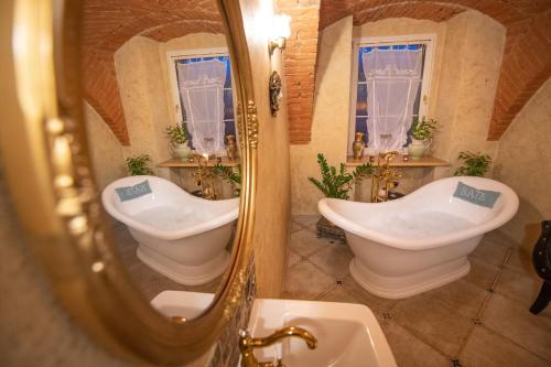 a bathroom with two sinks and a mirror at Rezydencja Grawert Boutique & Spa in Lądek-Zdrój