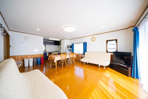 a living room with wooden floors and a dining room at Hachijyo-island Blue Eight -八丈島ブルーエイト- in Mitsune