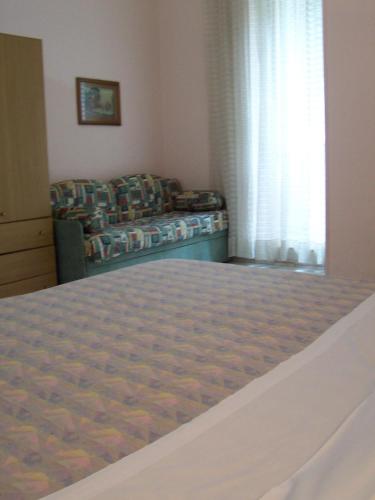 a bedroom with a bed and a couch and a window at Hotel Pensione Romeo in Bari