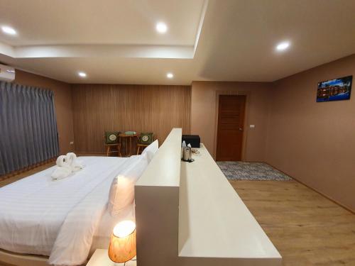 a bedroom with a large white bed and a television at USABAI Riverside Boutique Hotel in Chanthaburi