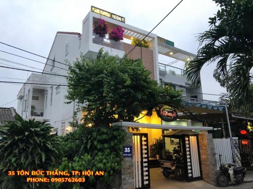 a building with a sign that reads as tom bikeking it ni ni am at Flame Flowers Homestay in Hoi An