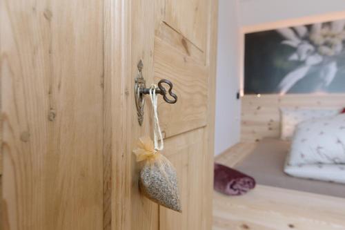a wooden door with a key in a bedroom at Ferienwohnung Berg Wieserhof in Aldino