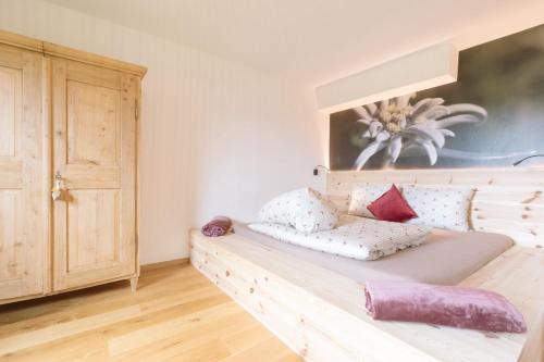 a bedroom with a wooden bed with pillows on it at Ferienwohnung Berg Wieserhof in Aldino