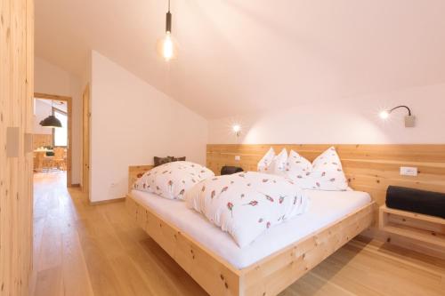 a bedroom with a bed with white sheets and pillows at Ferienwohnung Sea Wieserhof in Aldino