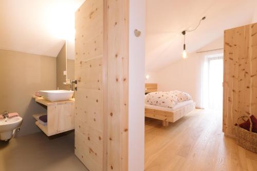 a bathroom with a sink and a bed in a room at Ferienwohnung Sea Wieserhof in Aldino