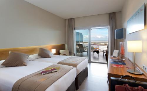 サン・ペドロ・デル・ピナタルにあるタラシア コスタ デ ムルシアのベッド2台とバルコニーが備わるホテルルームです。