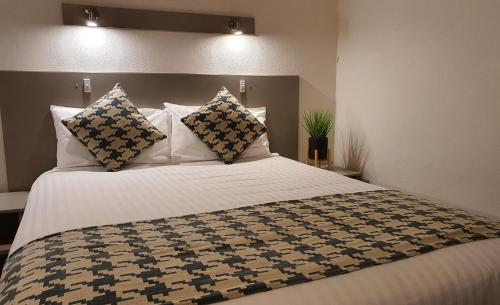 ein Schlafzimmer mit einem großen weißen Bett mit Kissen in der Unterkunft Cobb Inlander Motel in Hay