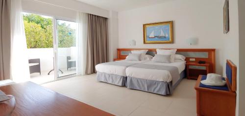 a bedroom with a large bed and a large window at Hotel Rocamarina - Adults Only in Cala d´Or