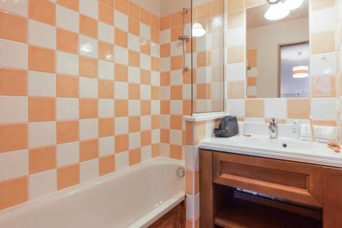 a bathroom with a sink and a tub and a mirror at Résidence Pierre & Vacances l'Albane in Vars