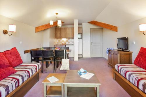 a living room with two couches and a kitchen at Résidence Pierre & Vacances l'Albane in Vars