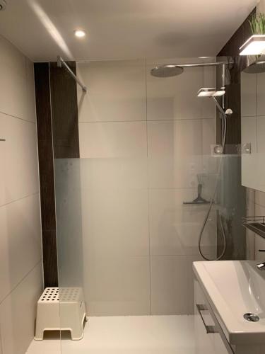 uma casa de banho com um chuveiro e um lavatório. em Appartement met zeezicht em Blankenberge