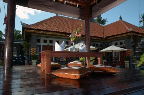 a wooden deck with a table and pillows on it at Kubu Garden Suites & Villas Nusa Dua in Nusa Dua