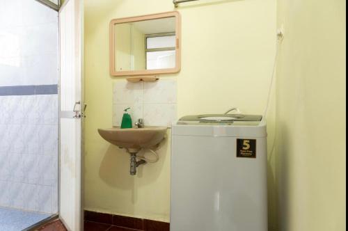 a small bathroom with a sink and a mirror at Cozy 2BHK villa in South Goa near the Beach!! in Utorda