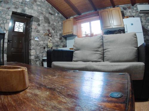 a living room with a couch and a table at Patras stonehouse with large yard - Πέτρινο σπίτι με αυλή in Paralía