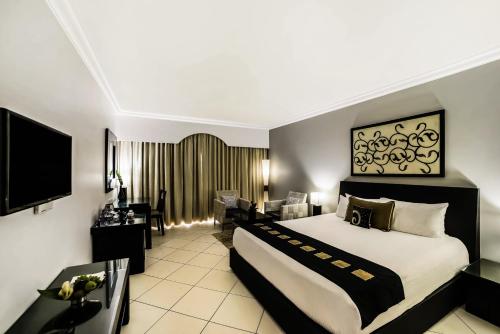a hotel room with a bed and a living room at The Zuri White Sands, Goa Resort & Casino in Varca