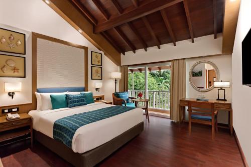 a bedroom with a bed and a desk and a window at Welcomhotel by ITC Hotels, Bay Island, Port Blair in Port Blair