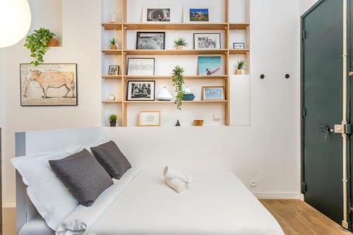- un lit blanc dans une chambre avec une étagère dans l'établissement SLEEPOO - Cocooning 6, à Paris