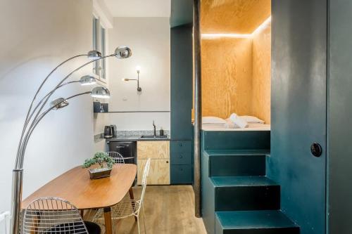 Cette petite chambre comprend une table et un lavabo. dans l'établissement SLEEPOO - Cocooning 6, à Paris