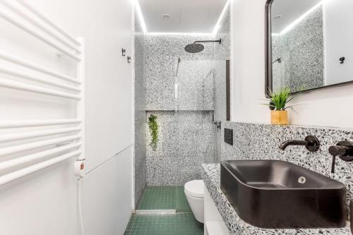 une salle de bain avec un lavabo noir et des toilettes dans l'établissement SLEEPOO - Cocooning 6, à Paris