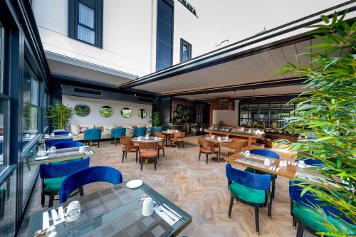 Un restaurante con sillas y mesas azules en un edificio. en Vital Hotel Fulya Istanbul Sisli, en Estambul