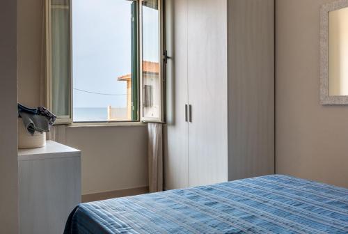 una camera con letto e finestra di Happy Sea Home Monolocale Angolo Cottura 4 pax ad Albinia