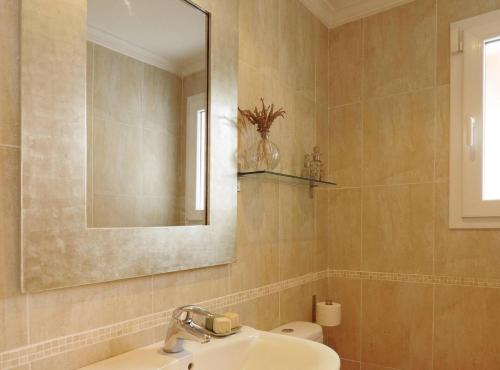 a bathroom with a sink and a mirror and a toilet at Villa Melissa - Plusholidays in Calpe
