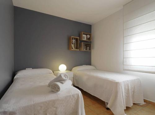 a bedroom with two beds with white sheets and a window at Villa Melissa - Plusholidays in Calpe