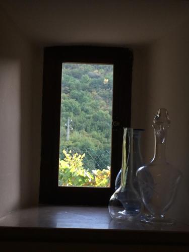 two glass vases sitting on a table in front of a window at LA CASETTA in Vallo di Nera