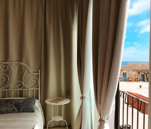 a hotel room with a bed and a chair at Regina Margherita B&B in Marzamemi