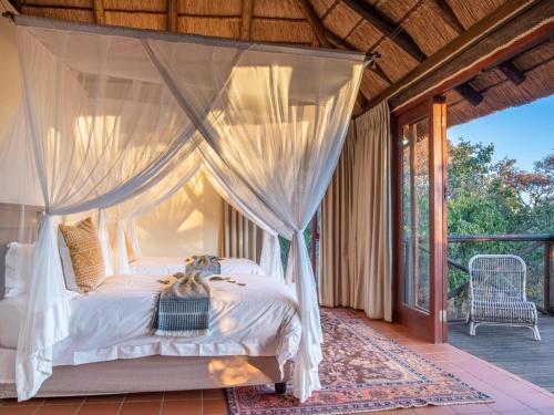 a bedroom with a canopy bed on a porch at Tintswalo Waterberg in Vaalwater