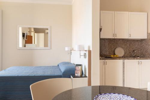 una camera con letto e tavolo e una cucina di Happy Sea Home Monolocale Angolo Cottura 4 pax ad Albinia