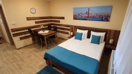 1 dormitorio con 1 cama y 1 mesa con comedor en Irány Colorado Apartman, en Nyíregyháza