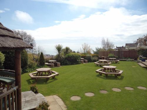 a garden with picnic tables on a lawn at The Mariners Hotel in Lyme Regis