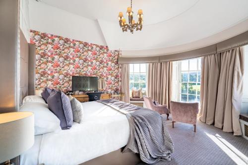 a bedroom with a large bed with a floral wallpaper at Banchory Lodge Hotel in Banchory