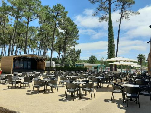a large group of tables and chairs and umbrellas at SevServices aux Dunes de Contis in Saint-Julien-en-Born