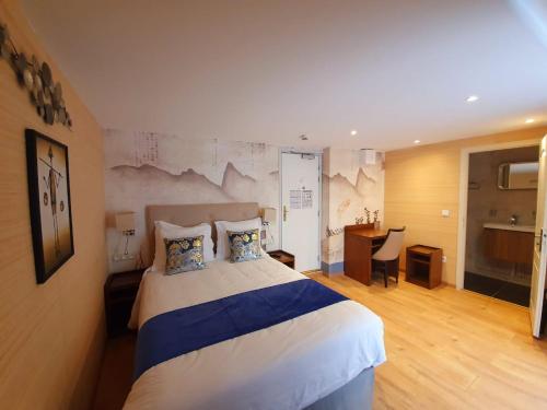 a bedroom with a large bed and a desk in it at Croix Blanche de Sologne in Chaumont-sur-Tharonne