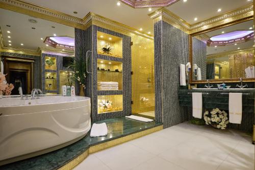 a bathroom with a tub and a large mirror at Club Hotel Sera in Antalya