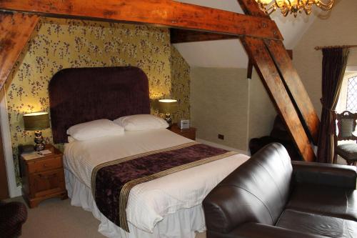 a bedroom with a bed and a dresser at Oakwood Hall Hotel in Bingley