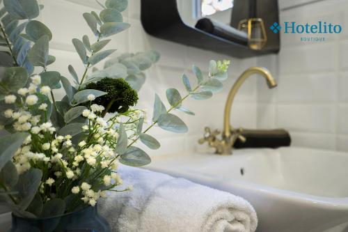 a bathroom with a sink and a vase of flowers at Hotelito Boutique Badalona Mar in Badalona