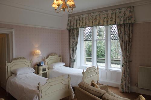 een slaapkamer met 2 bedden en een raam bij Oakwood Hall Hotel in Bingley