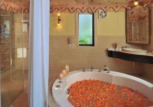 a bathroom with a bath tub filled with red flowers at Rajasthali Resort & Spa in Jaipur