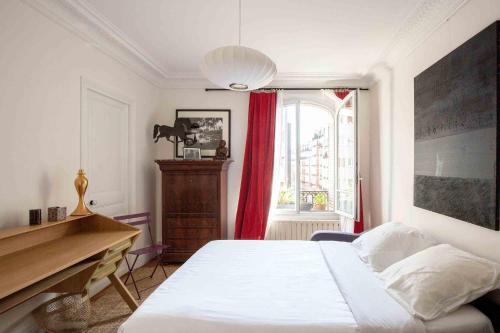 une chambre avec un lit, un bureau et une fenêtre dans l'établissement Veeve - Pastel Pinks in Paris, à Paris