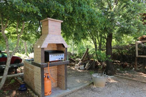 a brick oven sitting in a yard next to trees at Apartment Petra in Šilo