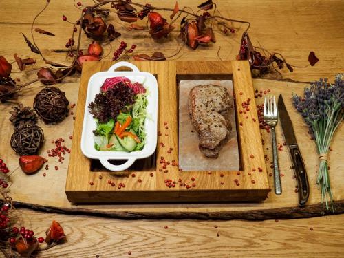 a wooden tray with a plate of food on a table at Hotel Am Schloss *** Superior in Tübingen