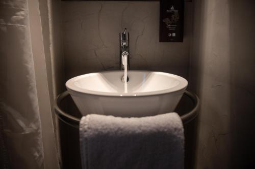 a bathroom sink with a faucet and a towel at Domotel Olympia in Thessaloniki