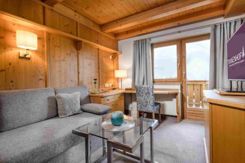 a living room with a couch and a table at Alpines Lifestyle Hotel Tannenhof in Sankt Johann im Pongau