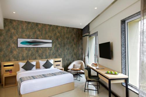 a hotel room with a bed and a desk at Click Hotel Bangalore - International Airport in Devanahalli-Bangalore